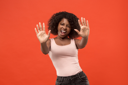 The happy african woman standing and smiling against red background.の写真素材