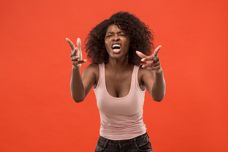 The young emotional angry woman screaming on red studio backgroundの写真素材