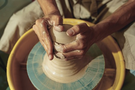 Creating a jar or vase of white clay close-up. Master crock.の写真素材