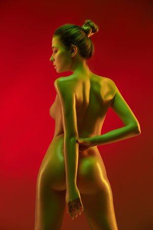 fashion art photo of elegant nude model in the light colored spotlightsの写真素材