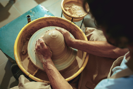 Creating a jar or vase of white clay close-up. Master crock.の写真素材