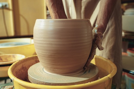 Creating a jar or vase of white clay close-up. Master crock.の写真素材