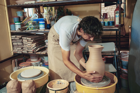 Creating a jar or vase of white clay close-up. Master crock.の写真素材