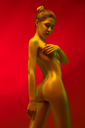fashion art photo of elegant nude model in the light colored spotlightsの写真素材