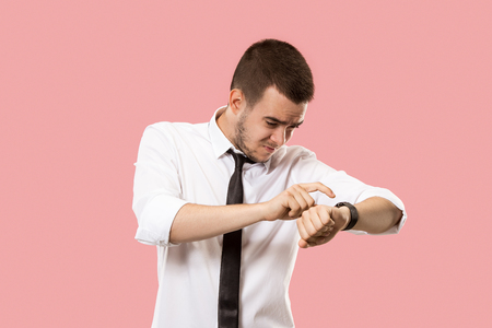 Handsome businessman checking his wrist-watch Isolated on pink backgroundの写真素材