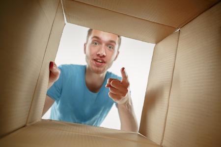 Man smiling, opening box and looking inside. The package, delivery, surprise, gift and lifestyle...