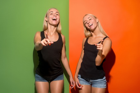 I choose you and order. The smiling women point you, want you, half length closeup portrait on studio background. The human emotions, facial expression concept. Front view. Trendy colorsの写真素材