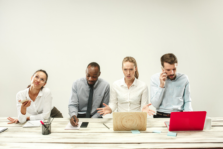 Young african and caucasian men and women sitting at office and working on laptops. The business, emotions, team, teamwork, workplace, leadership, meeting concept. different emotions of colleaguesの写真素材