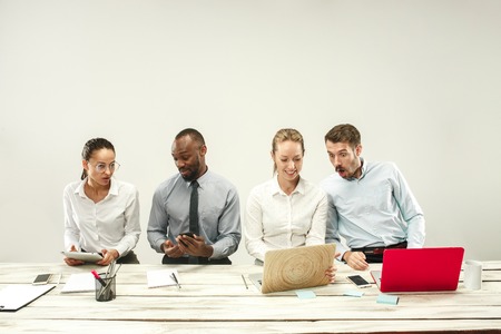Young african and caucasian men and women sitting at office and working on laptops. The business, emotions, team, teamwork, workplace, leadership, meeting concept. different emotions of colleaguesの写真素材