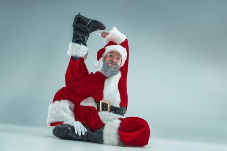 Funny serious guy with christmas hat dancing at studio. New Year Holiday. Christmas, x-mas, winter,...