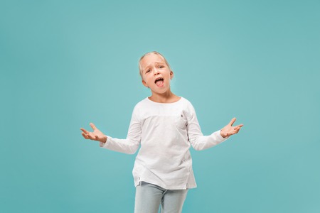 Why is that. Beautiful female half-length portrait on trendy blue studio backgroud. Young emotional surprised, frustrated and bewildered teen girl. Human emotions, facial expression concept.の写真素材