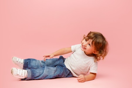 Portrait of happy joyful beautiful little boy, studio shot on pinkの写真素材