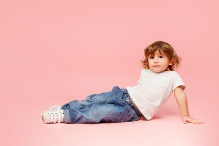 Portrait of happy joyful beautiful little boy, studio shot on pinkの写真素材