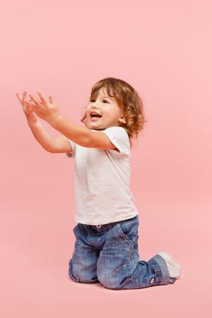 Portrait of happy joyful beautiful little boy, studio shot on pinkの写真素材