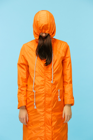 The young girl posing at studio in autumn jacket isolated on blue.の写真素材