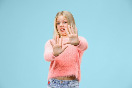 Reject, rejection, doubt concept. Young emotional teen girl at studio rejecting something against blue background. Human emotions, facial expression conceptの写真素材
