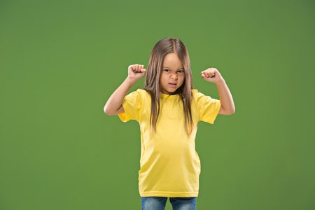 Angry teen girl standing on trendy studio background. Female half-length portrait. Human emotions,...