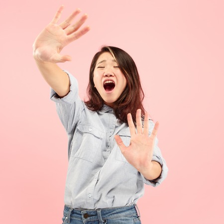 Im afraid. Fright. Portrait of the scared woman. Business woman standing isolated on trendy pink studio background. Female half-length portrait. Human emotions, facial expression concept. Front viewの写真素材