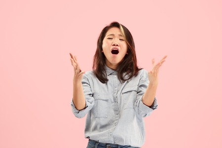 Screaming, hate, rage. Crying emotional angry woman screaming on pink studio background. Emotional, young face. Female half-length portrait. Human emotions, facial expression concept. Trendy colorsの写真素材