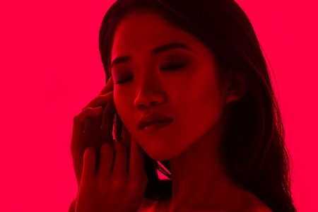 High Fashion model woman in colorful bright lights posing in studio, portrait of beautiful sexy girl...