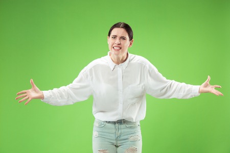 Argue, arguing concept. Beautiful female half-length portrait isolated on green studio backgroud....