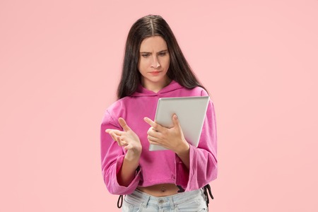 Businesswoman with laptop. Love to computer concept. Attractive female half-length front portrait, trendy pink studio backgroud. Young emotional pretty woman. Human emotions, facial expressionの写真素材