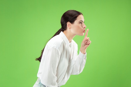 Secret, gossip concept. Young woman whispering a secret behind her hand. Business woman isolated on...