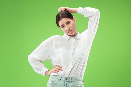 Why is that. Beautiful female half-length portrait isolated on trendy green studio backgroud. Young...