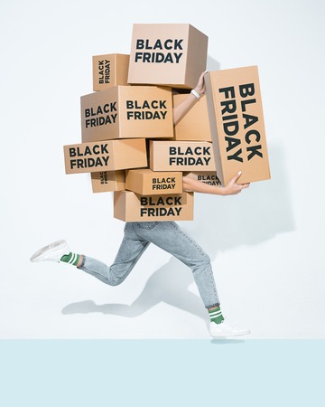 The lot of gift boxes in the hands of young man on white studio background. Cyber monday, shopping, black friday, sale, holiday, happy Christmas, sales season start conceptの写真素材