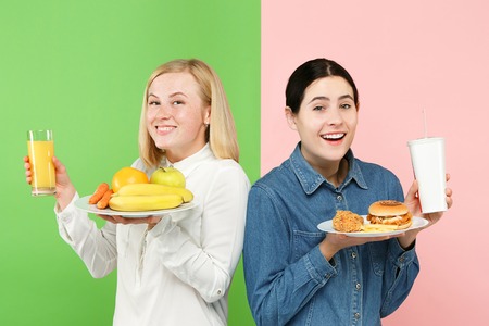 Diet. Dieting concept. Healthy useful food. Beautiful young women choosing between fruits and...