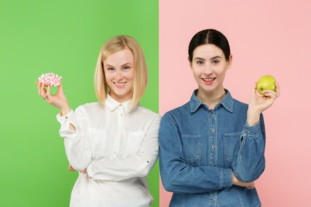Diet. Dieting concept. Healthy useful food. Beautiful young women choosing between fruits and...