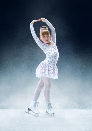 Little girl figure skating at the indoor ice arena. The dance, sport, winter, exercise, training, childhood, champion conceptの写真素材