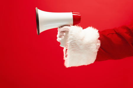 The hand of santa claus holding a megaphone on redの写真素材