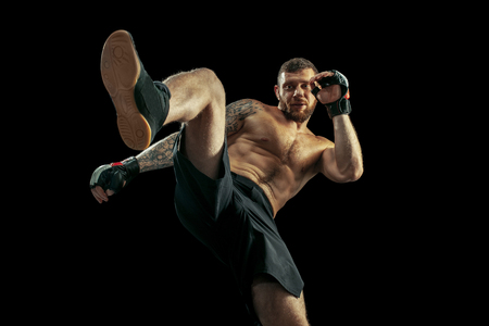 MMA. professional boxer boxing isolated on black studio background. fit muscular caucasian athlete fighting. Sport, competition, excitement and human emotions conceptの写真素材
