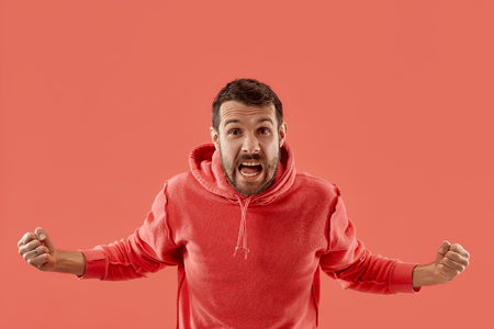 I won. Winning success happy man celebrating being a winner. Dynamic image of caucasian male model on coral studio background. Victory, delight concept. Human facial emotions concept. Trendy colorsの写真素材