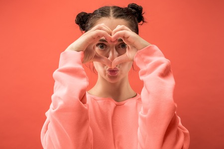 I kiss you ands love you. Portrait of attractive woman with kiss on lips. Coral studio. Beautiful...