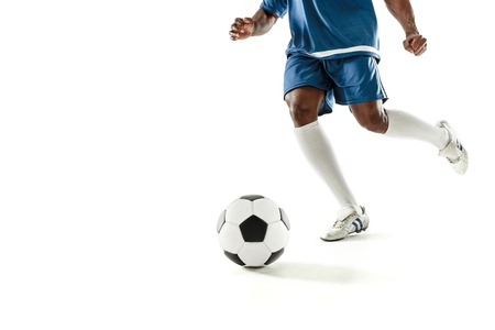 The legs of soccer player close-up isolated on white. African american model in action or movement with ball. The football, game, sport, player, athlete, competition conceptの写真素材