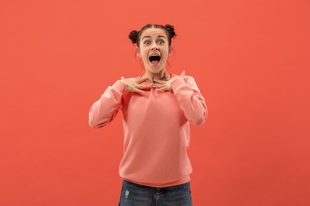 Delight. Beautiful female half-length front portrait isolated on coral studio backgroud. Young,...