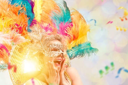 Beautiful young woman in carnival mask. Beauty model woman wearing masquerade mask at party over...