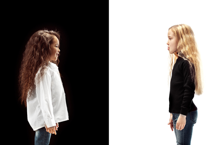 The portrait of two happy girls on a white and black studio