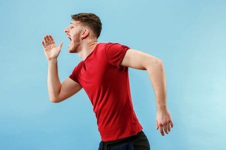 Do not miss. Young casual man shouting. Shout. Crying emotional man screaming on blue studio