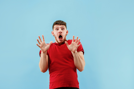 Im afraid. Fright. Portrait of the scared man. Business man standing isolated on trendy blue studio background. male half-length portrait. Human emotions, facial expression conceptの写真素材