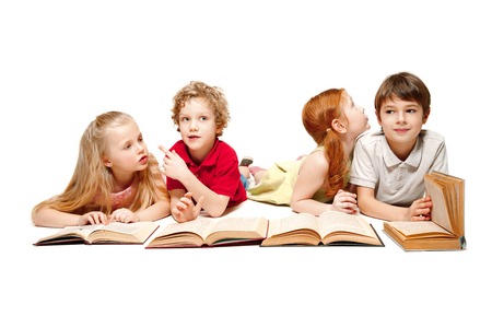 The kids boy and girls laying with books at studio, smiling, laughing, isolated on white.の写真素材
