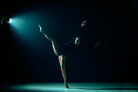 Young female ballet dancer dancing on neon lights studio background. Ballerina project with caucasian model. The ballet, dance, art, contemporary, choreography conceptの写真素材