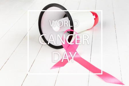 The text world cancer day and a pink ribbon with megaphone on a white wooden table background. The cancer, health, breast, awareness, campaign, disease, help, care, support, hope, illness, survivor, healthcare conceptの写真素材