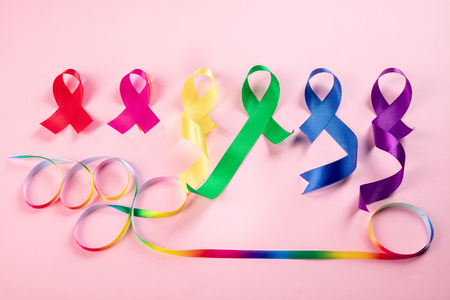 World cancer day on February 4. The colorful awareness ribbons - blue, red, green, pink and yellow color on pink background for supporting people living and illness. Healthcare and medicine conceptの写真素材
