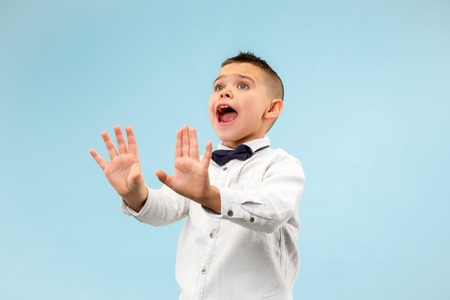 Im afraid. Fright. Portrait of the scared boy. Teenager standing isolated on trendy blue studio background. male half-length portrait. Human emotions, facial expression conceptの写真素材