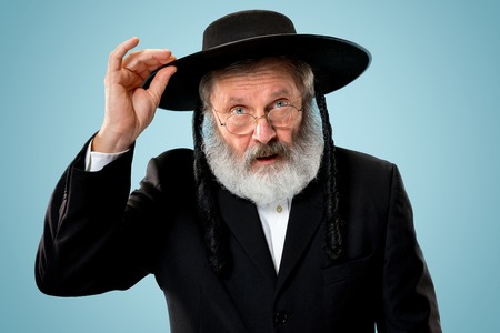 Portrait of old senior orthodox Hasdim Jewish man with wooden Grager Ratchet at Jewish festival of...