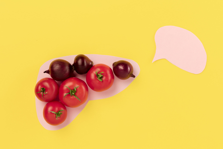 Cholesterol diet and healthy food nutritional eating for cardiovascular disease reduction concept with fresh vegetables in paper liver on yellow background. Conceptual composition with copyspaceの写真素材