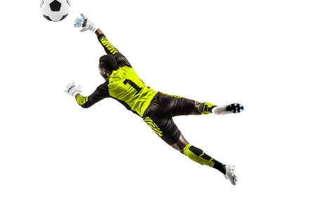 Male soccer player goalkeeper catching ball in jump. Silhouette of fit man with ball isolated on white studio backgroundの写真素材